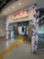 Entrance to Sapporo Olympic Museum with colorful Olympic rings. Purple geometric patterns decorate walls; yellow tactile paths guide visitors.