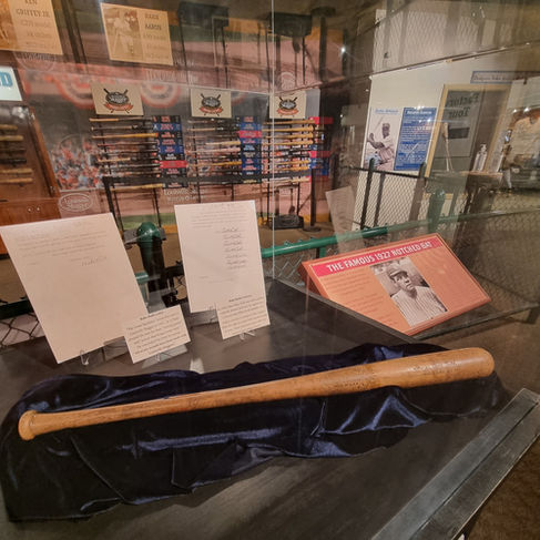 display in glass case holding exhibits from the baseball museum a few signed letters plus a vintage bat