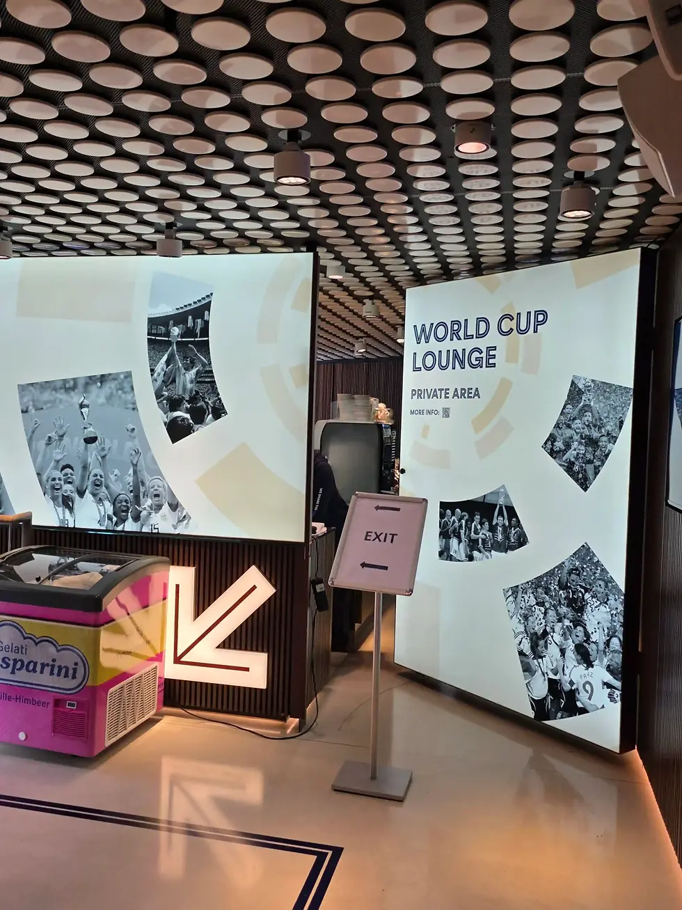 World Cup Lounge private area with exit sign, photo panels of celebrating fans, and a polka-dot ceiling at the FIFA Museum.