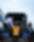 Three men load Lando Norris's orange and blue McLaren Formula 1 car with sponsor logos onto a truck under a cloudy sky, conveying focus and teamwork.