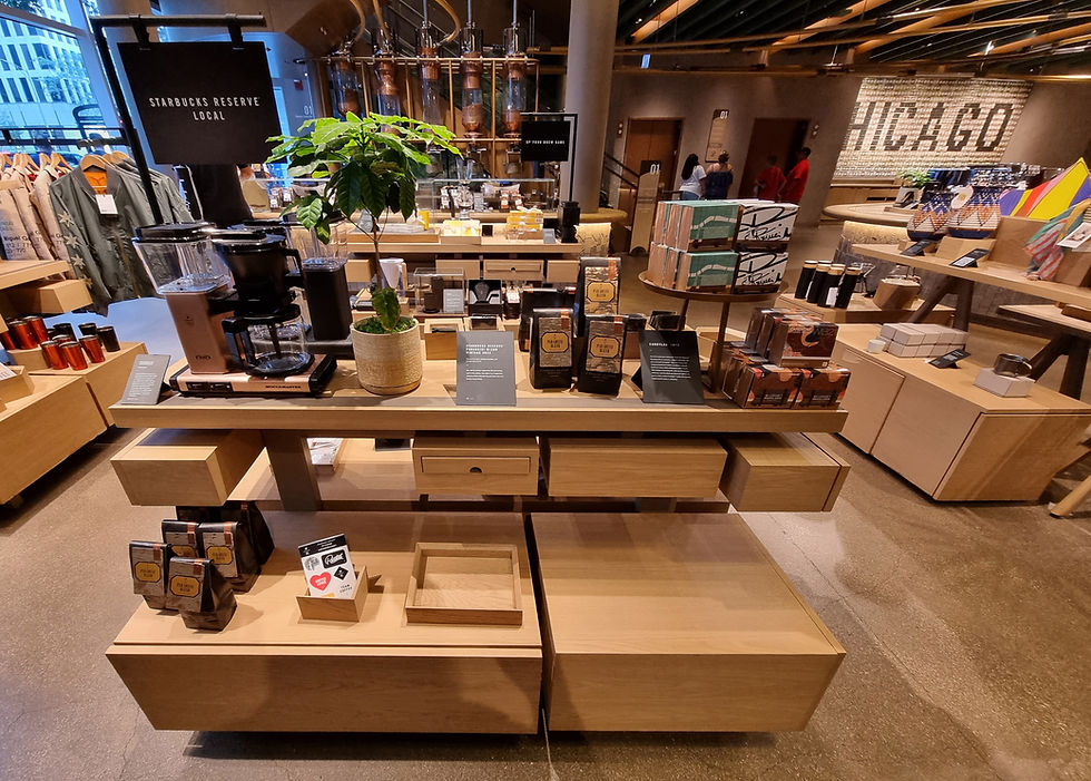 Starbucks Reserve shop interior with coffee display, wooden shelves, plant, and "CHICAGO" on wall. Warm lighting, casual atmosphere.