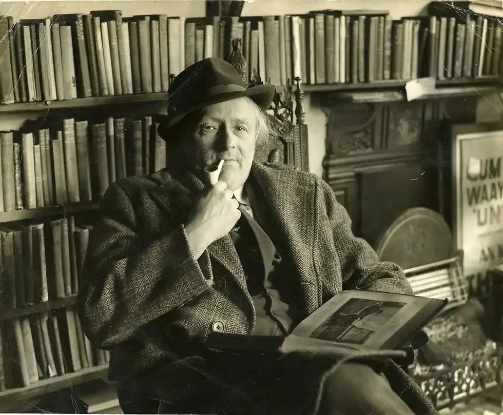 Kit Calvert as an Elderly man in a suit and hat smokes a pipe while reading in a cozy library, surrounded by bookshelves. Relaxed, vintage atmosphere.