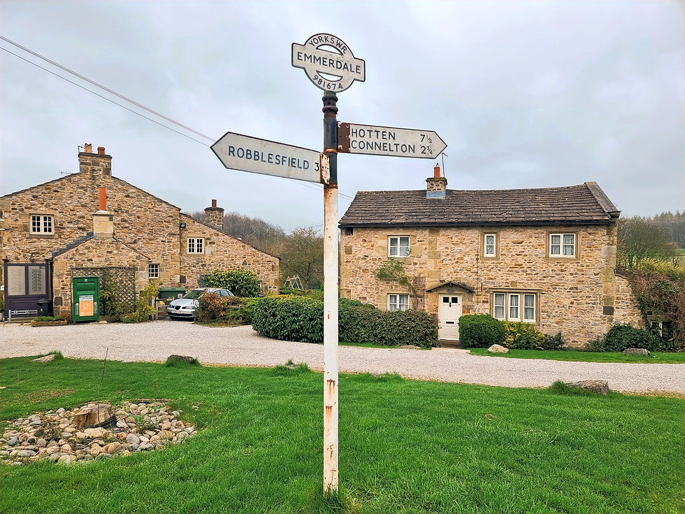 Emmerdale TV soap opera show set, several cottages from the show, road signs and countryside, all at the Emmerdale Village tour and visitor centre for the itv brand