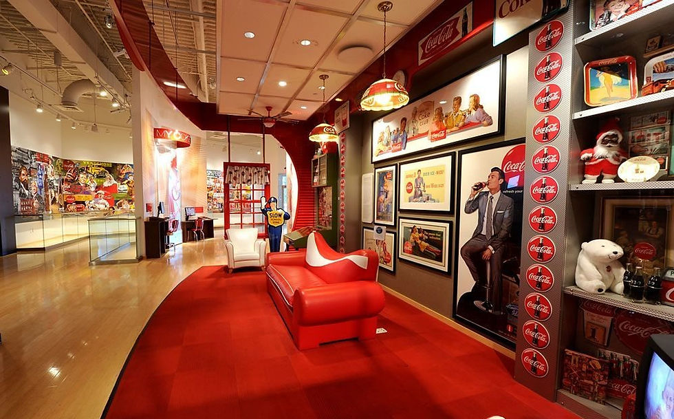 Coca-Cola themed room at World of Coca-Cola with red and white decor, vintage ads, and memorabilia. Cozy seating and a warm, nostalgic atmosphere.
