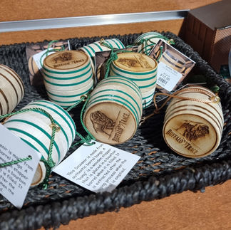 mini wooden barrels with green bands round them are emblazoned with the buffalo trace logo and hang from green ribbons as christmas ornaments