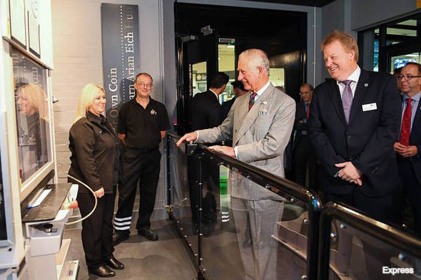 king charles III visiting the royal mint with staff members and visitors around him