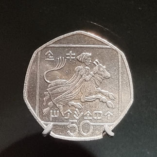 silver coloured foreign coin 50 written on it