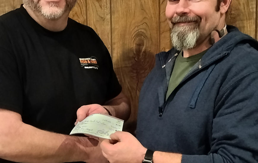 Banquet Chairman hands President of Fish & Game a check from banquet proceeds