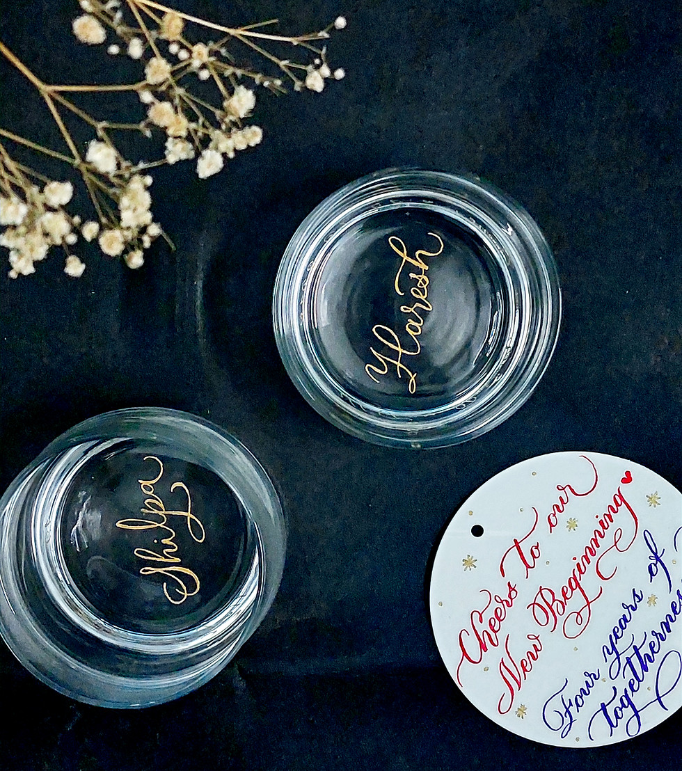 Close up of custom engraved couple names on whiskey glasses handcrafted calligraphy