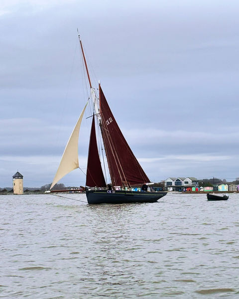 Heritage Sailing Smack 'Maria', Bateman's Tower and Brightlingsea beach huts in background