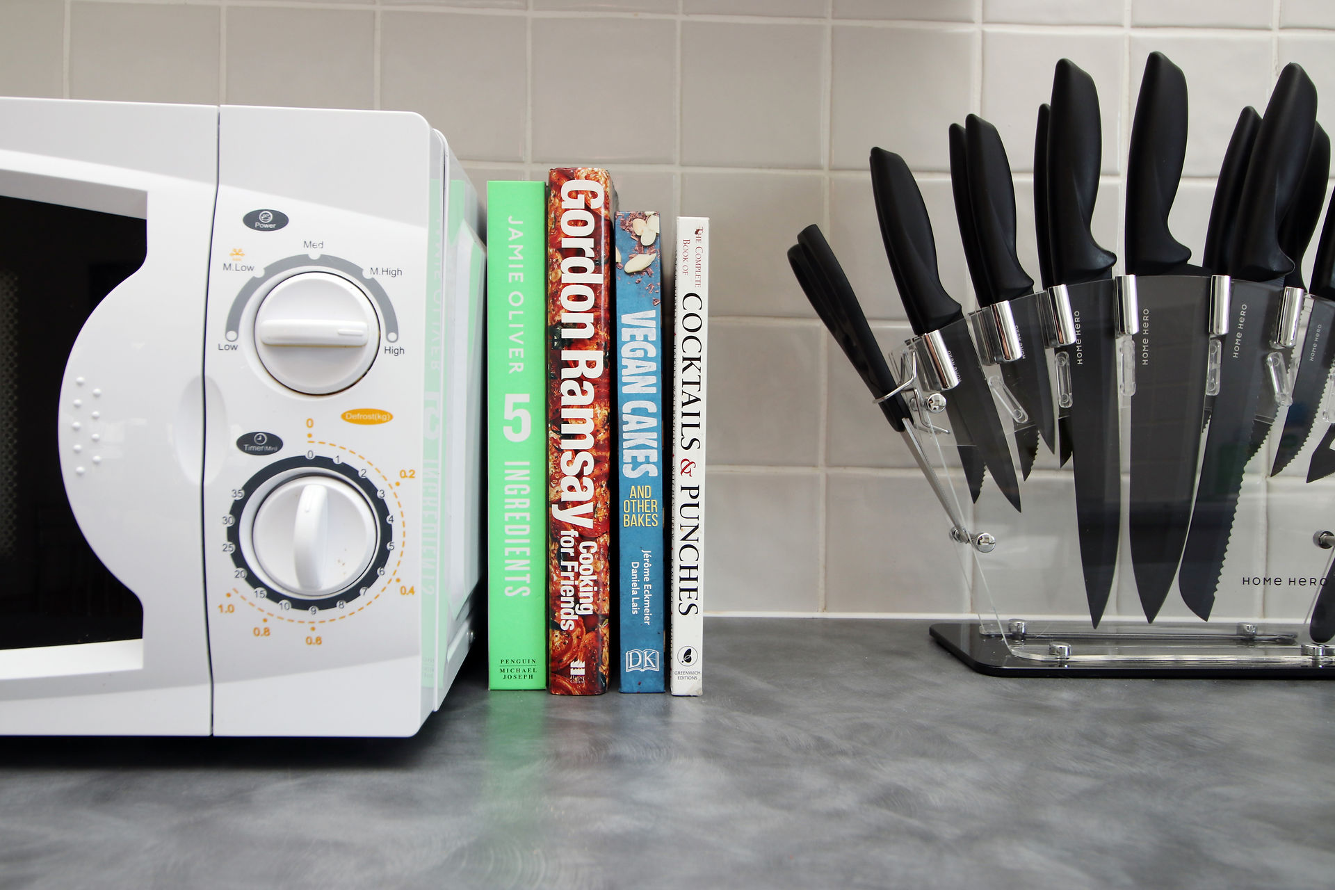 A microwave and cutlery set in the modern kitchen at Dray Court by AirFreedom, providing convenience and functionality for guests. Enjoy the ease of preparing meals and dining in style during your stay in Cardiff. Experience luxury living with all the amenities you need!