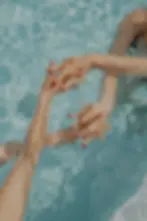 Confident women holding hands in the swimming pool