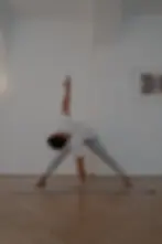 Man stretching into a yoga pose in a yoga studio