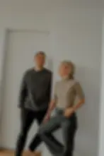 yoga man and yoga woman laughing at each other in a light room