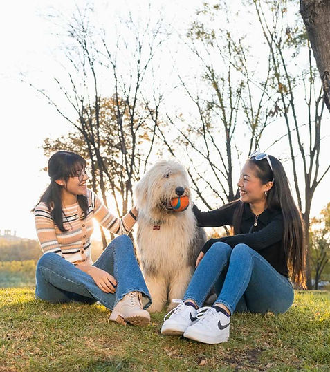 Residents relaxing with a dog in a neighborhood park, highlighting a welcoming and well-managed community environment.