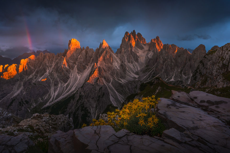 rainbow and red light in the cadini, dolomites, italy