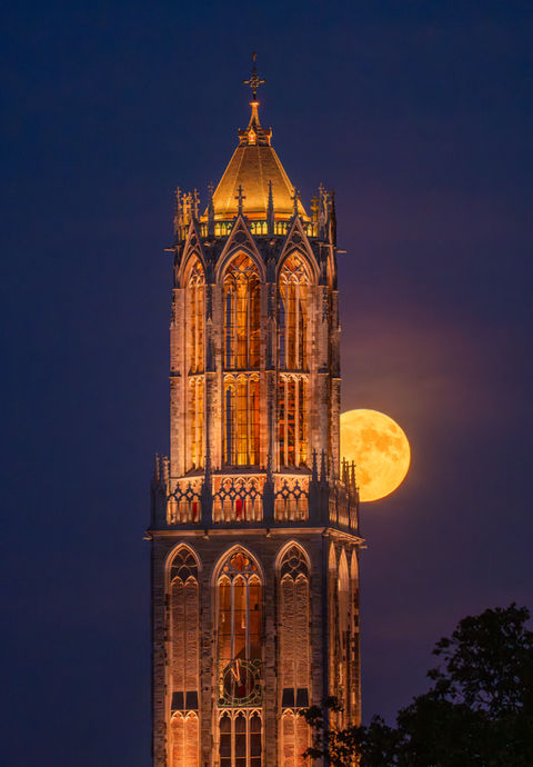 dom tower in Utrecht with the moon next to it.