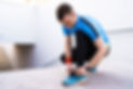 man-tying-his-sport-shoes-concrete-background-min.jpg