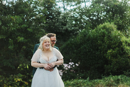 Bride and groom hugging and laughing after their wedding ceremony.
