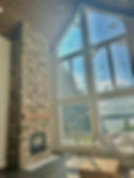 Fieldstone fireplace in tall cathedral ceiling livingroom.