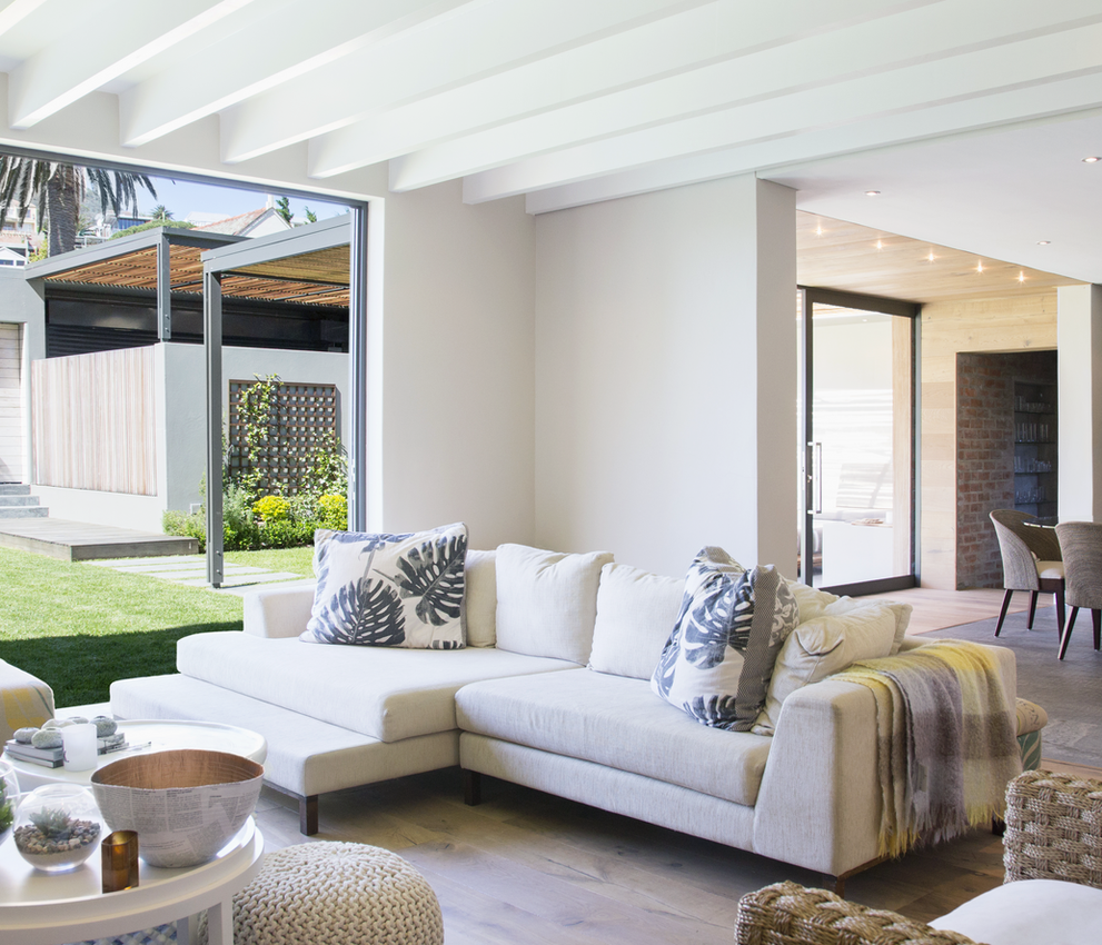 Modern living room with a white sofa, open to the backyard