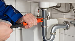 Plumber fixing basin/kitchen trap in West London