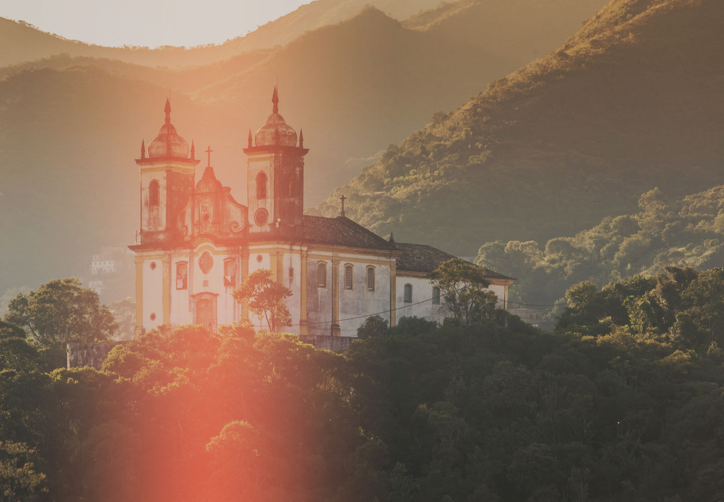 Église coloniale à Ouro Preto sous le soleil couchant.
