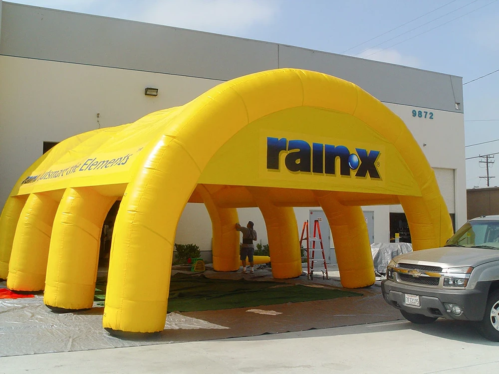 Yellow branded inflatable commercial tent structure with multiple entry openings set up outdoors for an event activation.