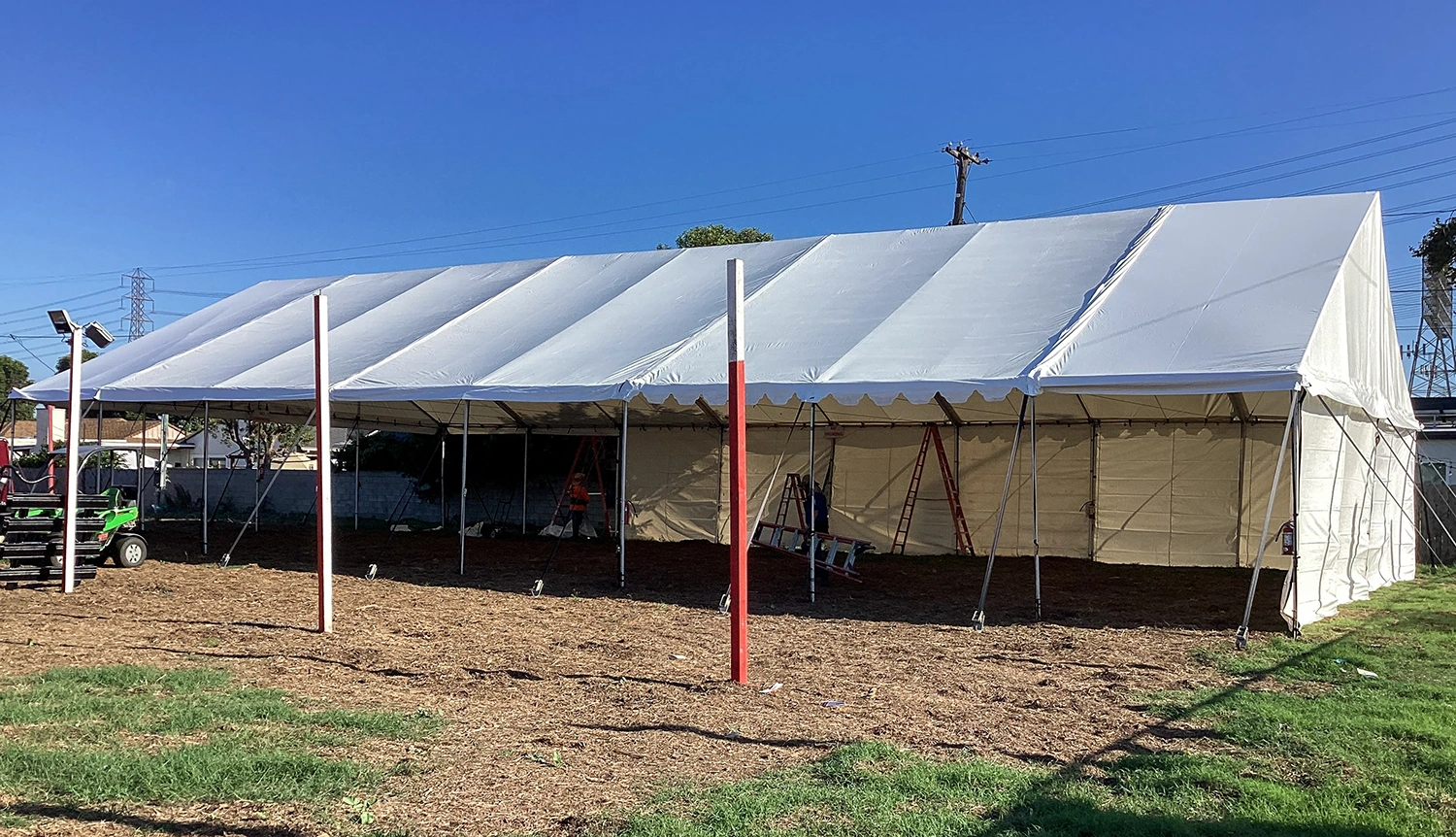 Large gable tent with high walls set up outdoors, designed for events and storage.