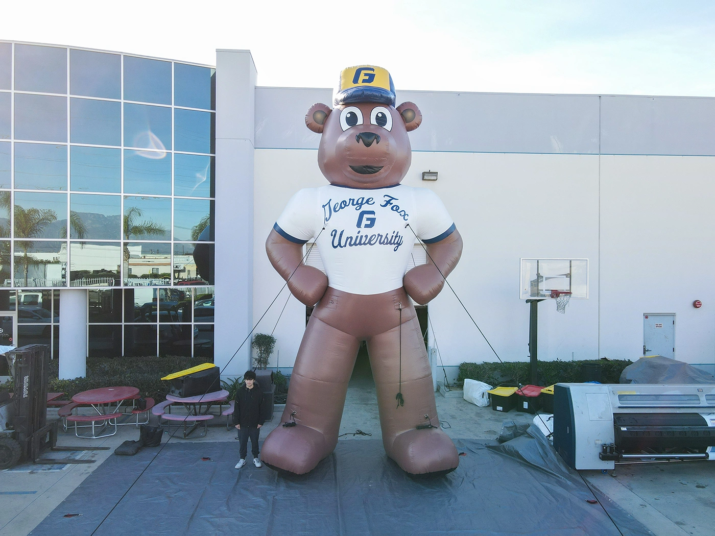 Towering inflatable bear dressed in George Fox University gear, designed for promotional use at recruitment fairs, orientation, and sporting events.