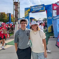 Inflatable FOX Big Noon Kickoff arch at a college football event with attendees posing in front.
