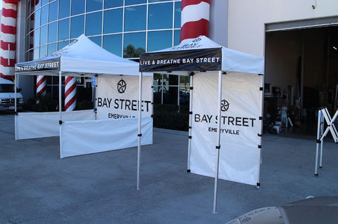 Branded 5x5 canopy tents with Bay Street Emeryville graphics and sidewalls