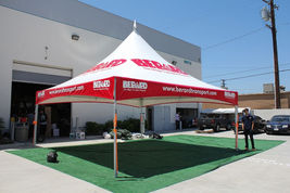 Large branded event tent with custom red printed valance outdoors