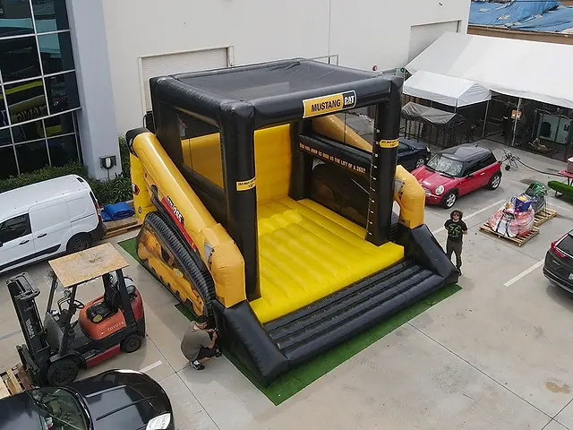 Custom inflatable bulldozer bounce house used for interactive event entertainment and promotional activities.