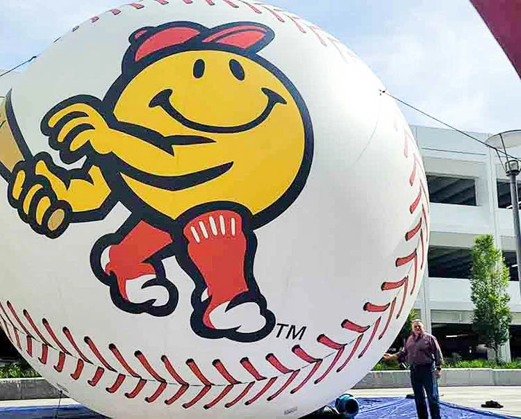Custom giant inflatable baseball with printed mascot logo, oversized inflatable sports display used for promotional and event marketing.