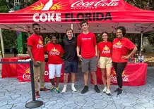 Coca Cola custom canopy tent with branded top and promotional staff at outdoor event.