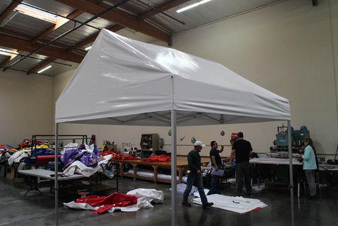 Plain white gable frame tent displayed inside production facility for testing