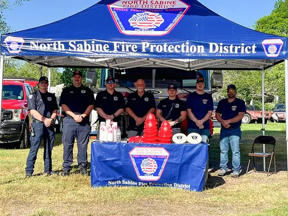 A fully branded 10x10 custom canopy for the North Sabine Fire Protection District, designed for outreach events and public safety awareness. Includes a printed top, valances, and a matching table cover.