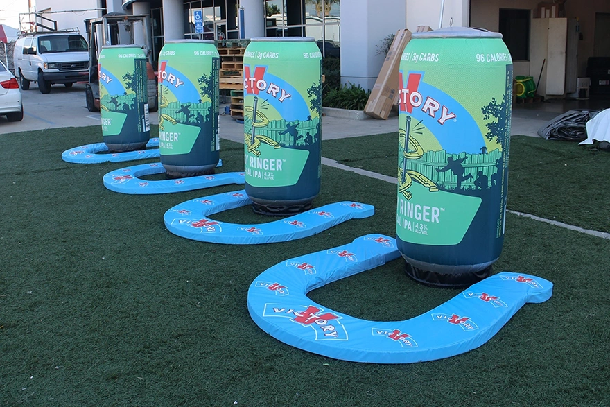 Custom inflatable can toss game featuring branded beverage cans at an outdoor promotional event