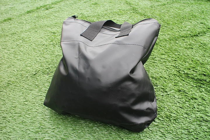 Upright view of black canopy sandbag positioned on green turf