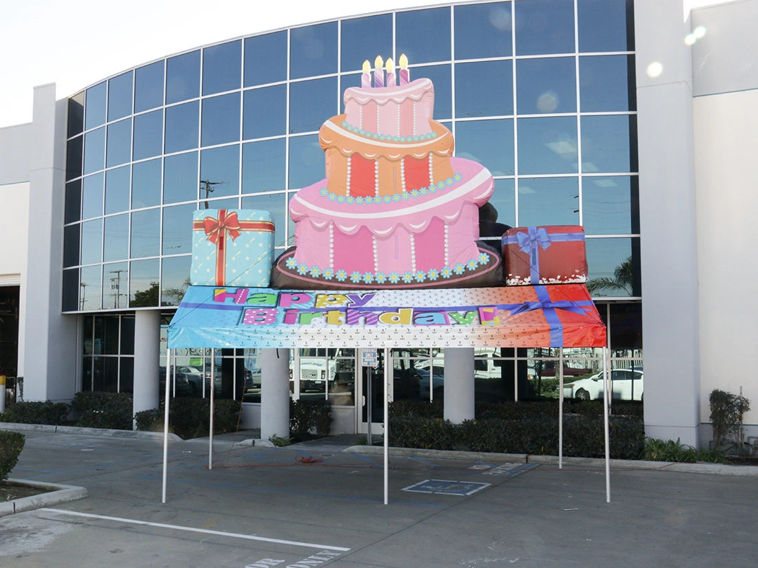 Happy Birthday gable tent with elevated inflatable cake topper for birthday event setup
