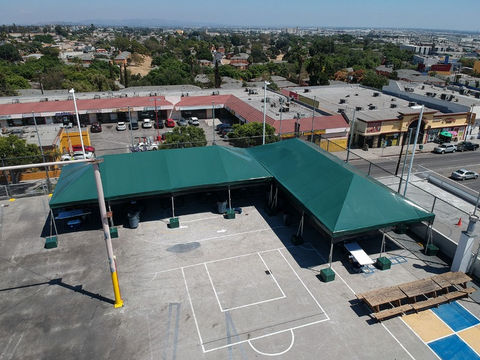 Overhead view of large green commercial frame tents installed across a school playground