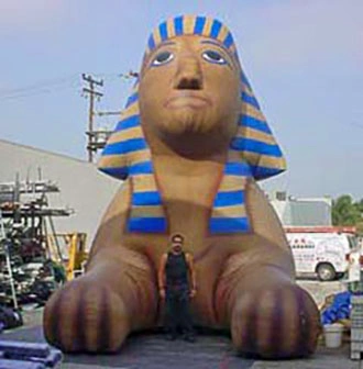 Giant inflatable sphinx viewed from the front with a person standing in front for scale.
