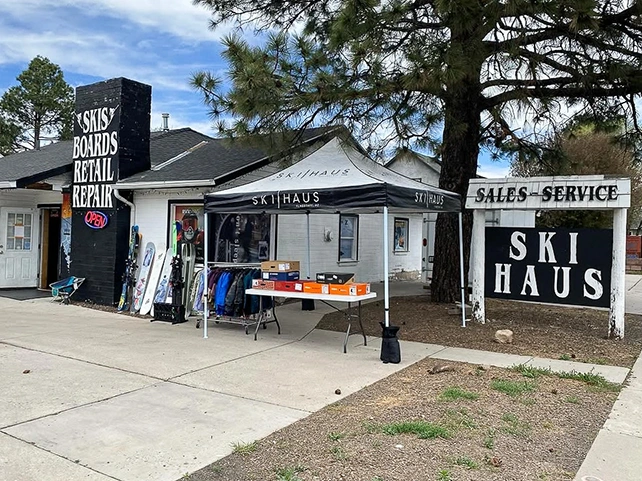 Ski Haus pop up canopy setup outside retail storefront with boards and gear