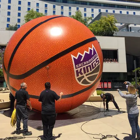 Large inflatable basketball with Sacramento Kings logo at an outdoor sports marketing event.