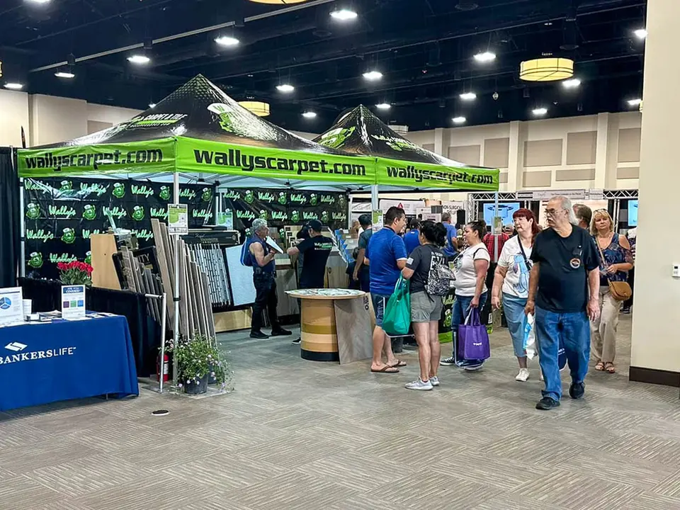 Custom 10x20 trade show tent with high peak top and printed walls at an indoor expo event