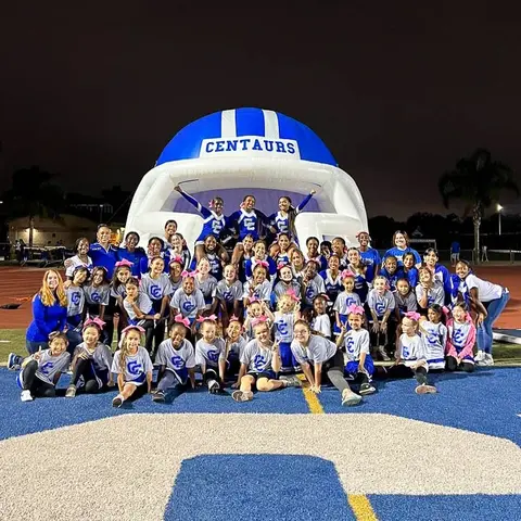 Inflatable football entrance tunnel branded for the Centaurs team, surrounded by players and fans.