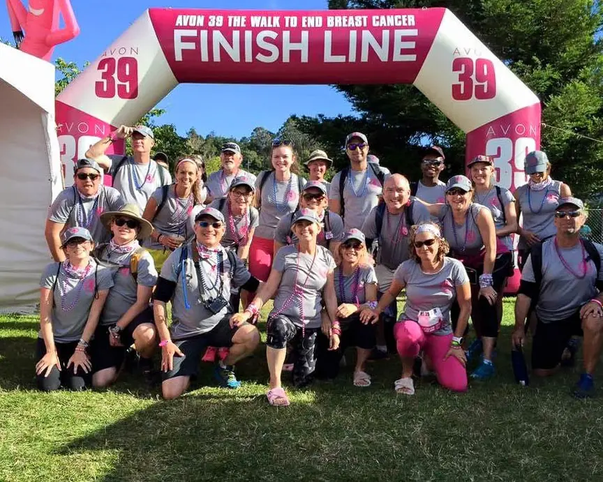 Avon 39 Breast Cancer Walk custom inflatable finish line arch with participants posing underneath.