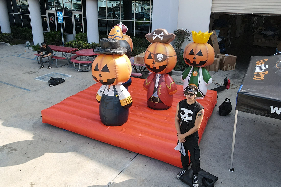 Halloween inflatable ring toss game with pumpkin character targets on an inflatable base set up outdoors for a seasonal event activation.