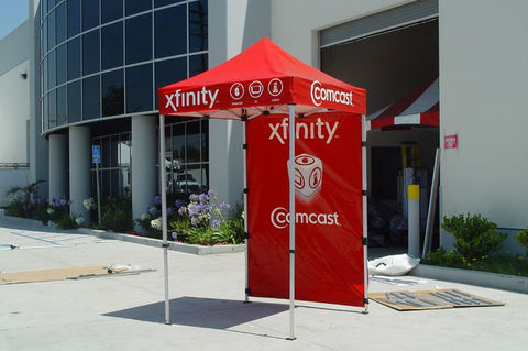 Xfinity 5x5 pop up canopy tent with Comcast logos set up for a storefront promotion